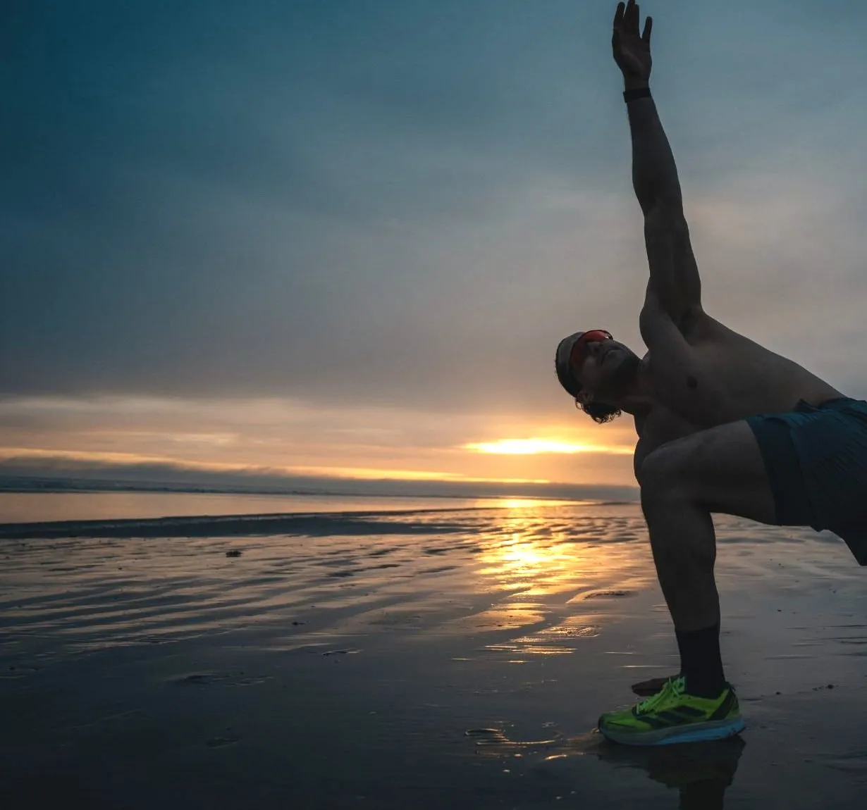 Moe stretching on a wet beach at sunrise, in black and white